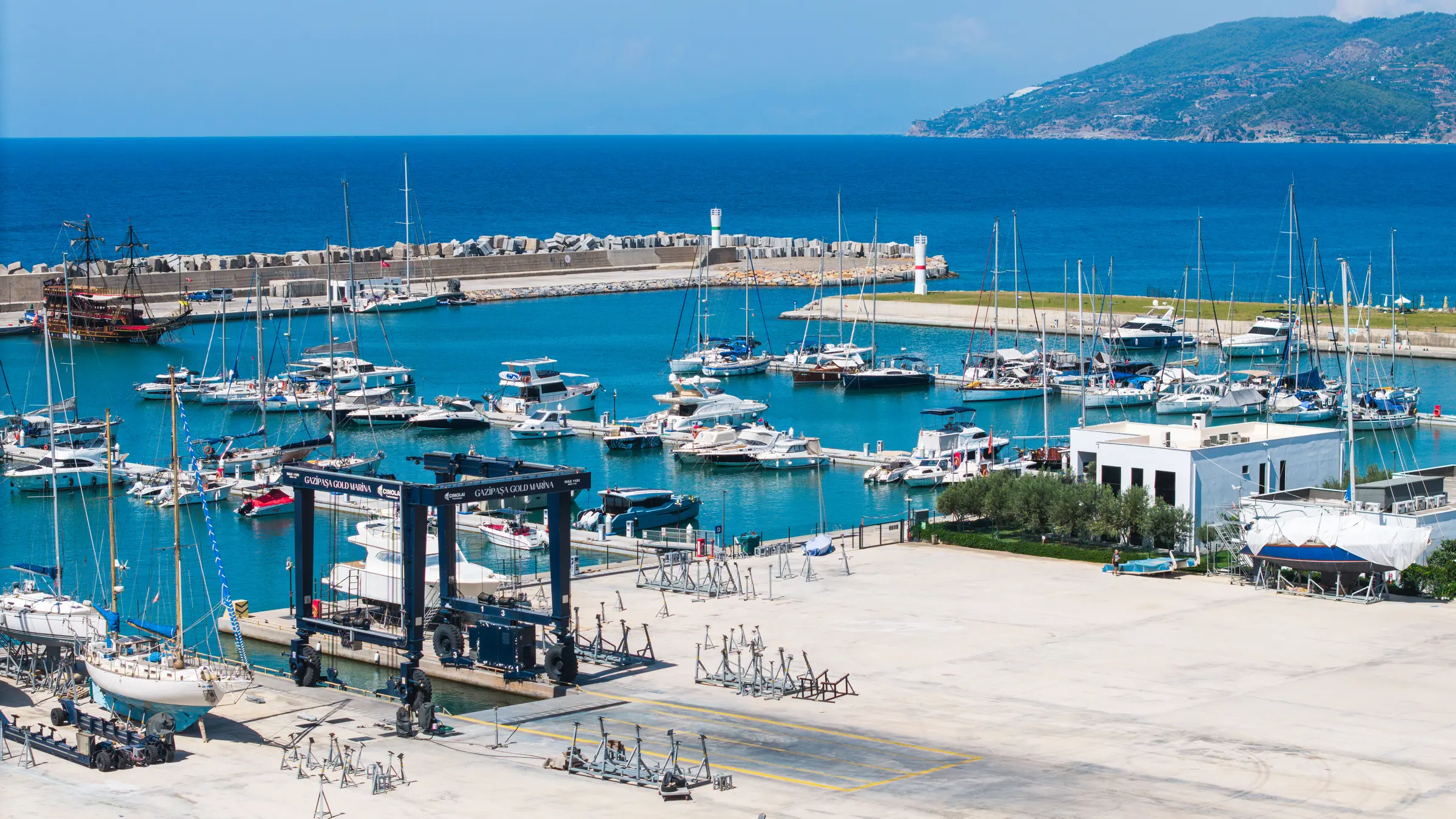 Travel lift and boatyard with the mooring basin full of yachts behind