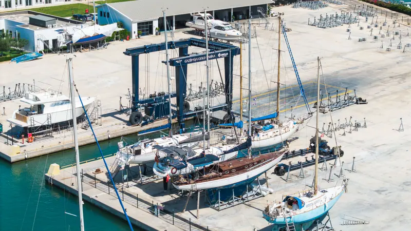 Sailing yachts and motor yachts in winter storage beside the travel lift in the boatyard